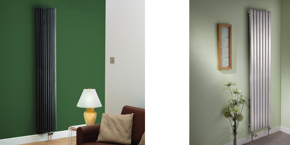 Two modern radiators: black on green wall near lamp and sofa, silver on light green wall beside plant.