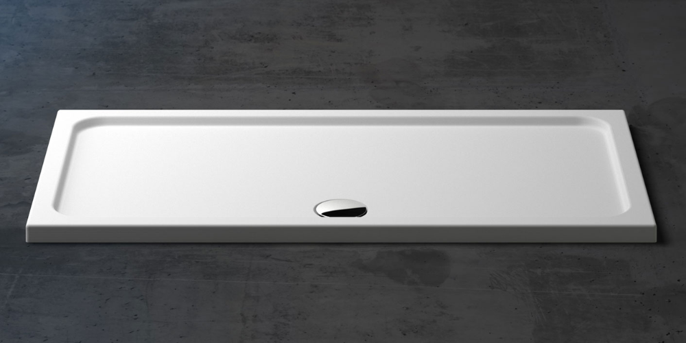 White rectangular shower tray with central drain on dark textured concrete floor, minimalist and sleek design