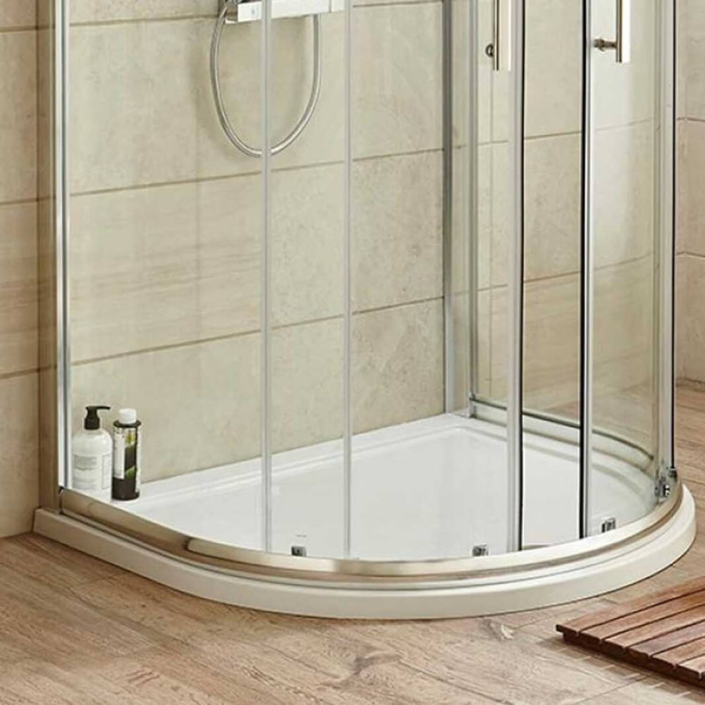 Corner D-shaped shower tray with clear glass doors, metal frame, beige tiles, and wooden floor