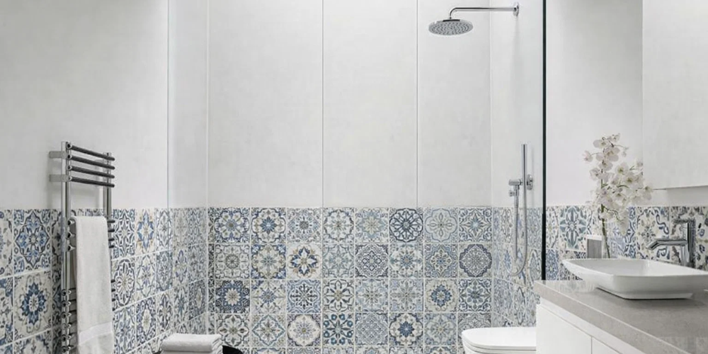 Bathroom with blue and white patterned wall panels, compact basin, and chrome towel rail.