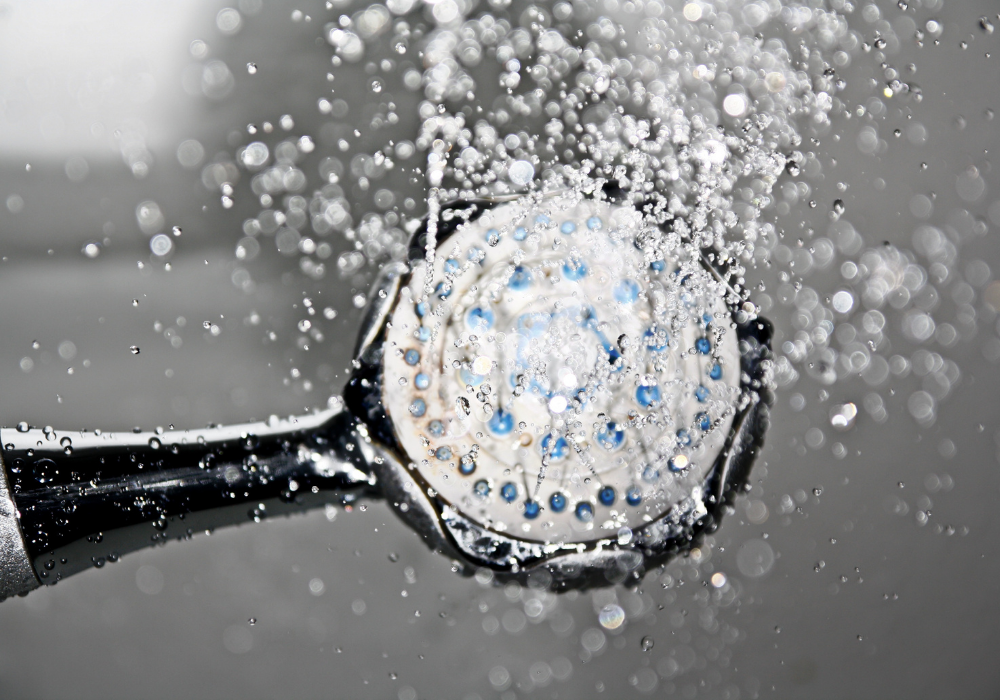 hand held shower head spraying water