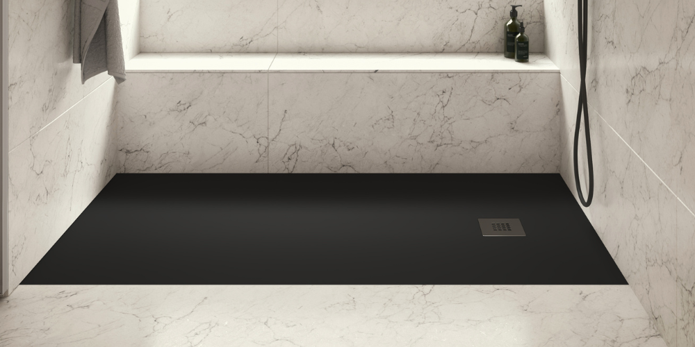Luxurious bathroom with black shower tray, marble walls, built-in shelf with green bottle, and hanging towel