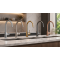 Kitchen tap finishes comparison showing silver, brushed brass, black, and copper mixer taps on marble worktop.