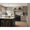 Grey kitchen with black island, marble worktops, herringbone flooring, pendant lighting, and black range cooker with brass details.