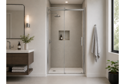 Sliding glass shower doors beside wall-mounted basin, mirror, and corner plant in a light bathroom interior.