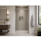 Sliding glass shower doors beside wall-mounted basin, mirror, and corner plant in a light bathroom interior.