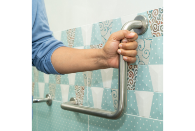 hand Grabbing support rail in bathroom